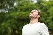 © Antonioguillem - Relaxed adult man breathing fresh air in a forest
