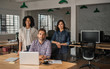 © mavoimages - Smiling group of young designers working at an office desk