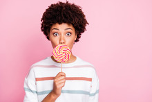 Photo Of Pretty Dark Skin Wavy Lady Holding Big Round Lollipop On Stick Hiding Mouth Keeping Silence Wear Striped Pullover Isolated Pastel Pink Color Background