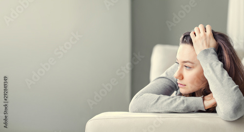 Cuadros en Lienzo Depressed young woman on sofa at home.