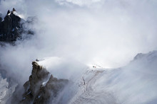 Snowy Amountsin Peaks In Alps With Small Unrecognizable Figures Of Alpinists