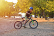 © Daniel CHETRONI - Happy kid boy of 7 years having fun in autumn park with a bicycle on beautiful fall day. Active child wearing bike helmet