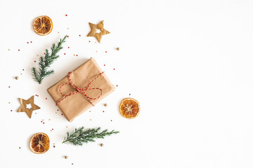 Christmas composition. Gift box, fir tree branches, golden decorations on white background. Christmas, winter, new year concept. Flat lay, top view, copy space