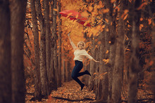 Girl With A Red Umbrella, Flying On An Umbrella, Jumping And Having Fun In A Yellow Autumn Landscape