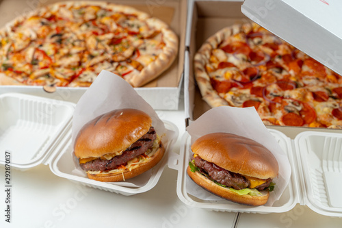 Unhealthy snacks delivery in boxes: italian margherita and chicken pizza, beef burgers with cheddar cheese © Tkachenko Alexey