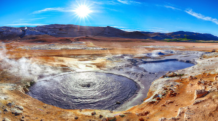 Boiling mudpots in the geothermal area Hverir and cracked ground around.