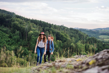 Wall Mural - young tourist couple travellers with backpacks hiking in nature.
