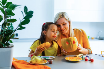 Wall Mural - mother and daughter play with carved pumpkin at home