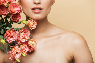 Wall Mural - Cropped image of half-naked woman poising at camera with flowers