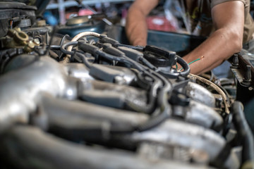 hands of mechanic repairing the car's engine close up