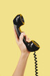 © DragonImages - Hand of person holding black telephone receiver