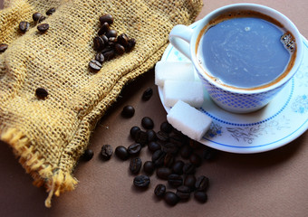 cup of coffee with beans and grinder