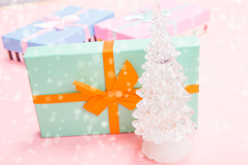 Poster - glass white Christmas tree with gifts with bows on a pink