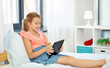 © Syda Productions - children, technology and communication concept - smiling girl with tablet computer sitting on bed at home