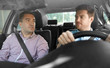 © Syda Productions - car driving lesson and carpooling concept - instructor on passenger seat and young driver talking