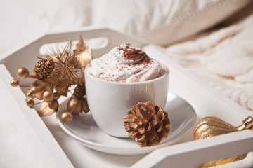 Cup of cocoa on the white tray on the bed early winter morning