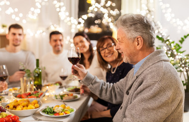 Poster - celebration, holidays and people concept - happy family having dinner party, drinking red wine and toasting at home