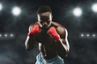 © Prostock-studio - Young fighter in boxing stance staying on stadium arena