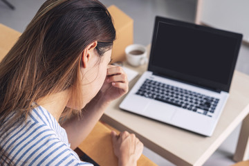 Stressed and frustrated asian business woman holding head in hands