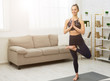 © Prostock-studio - Slim woman practicing yoga in tree pose at home