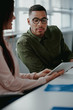 © StratfordProductions - Close-up of a businesswoman showing something on digital tablet to her male colleague in office meeting