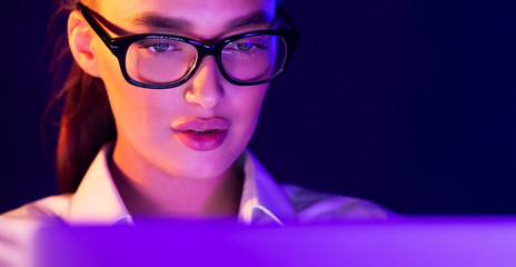Young woman working on laptop late at night