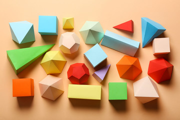 Colorful paper geometric figures on beige background