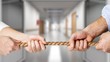 © BillionPhotos.com - Business people pulling rope in opposite directions at office