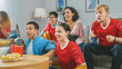 © Gorodenkoff - At Home Diverse Group of Sports Fans Wearing Team's Uniform Watch Sports Game Match on TV, They Cheer for the Team, Celebrate Victory after Team Scores a Winning Goal. Cozy Room with Snacks and Drinks