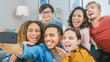 © Gorodenkoff - At Home Diverse Group of Friends Doing Collective Selfie, Guy Holds Smartphone People Smile, Laugh and do Duck Lips.Young People Doing Live Stream of the Home Party.