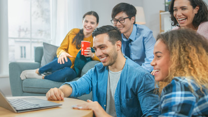 Wall Mural - Diverse Group of Friends Use Laptop in the Living Room. Happy Beautiful Girls and Guys Live Streaming or Watching Content. They Have Fun and Laugh.