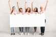 © Prostock-studio - Multiethnic Women Wearing Pink T-Shirts Holding White Board Indoor, Mockup
