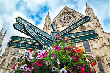 the york minster and a sign with directions to landmarks in the city