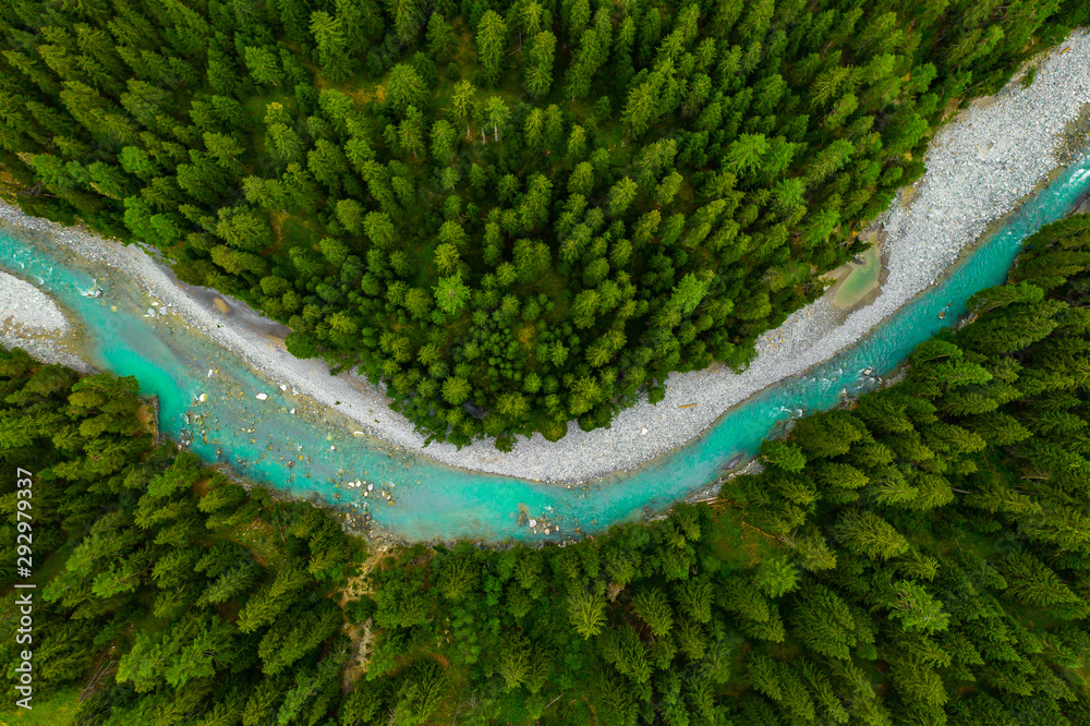 Inn River flowing in the forest in Switzerland. Aerial view from drone on a blue river in the mountains - obrazy, fototapety, plakaty 
