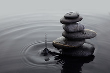 Zen Stones In Balanced Pile In Water On Rippled Water Surface And Water Drop.