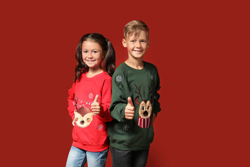 Wall Mural - Cute children in Christmas sweaters showing thumb-up on color background