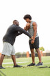 © digitalskillet1 - American Football coach training a young athlete.