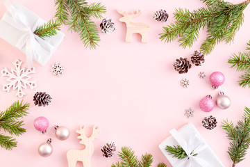 flat lay frame with spruce branches, christmas decorations and gift box on a color background