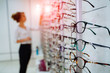 Eyeglasses shop. Woman trying on glasses in optical store