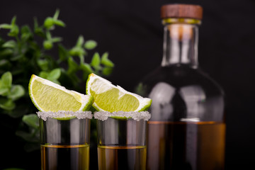 Wall Mural - Mexican Gold Tequila with lime and salt on black background with copyspace.