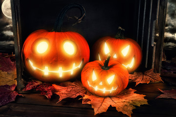 Wall Mural - Scary horror background with Halloween pumpkins jack o lantern, placed on a wooden crate.