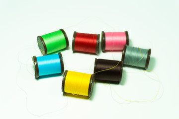 Sewing threads in colors various Such as Blue, yellow, green, pink, brown, red, gray on the white background.crafts concept