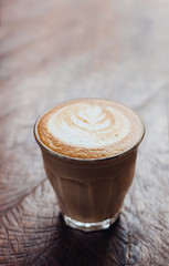 Wall Mural - Close up coffee cup with latte art on grunge wood table at cafe