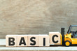 Toy forklift hold letter block c to complete word basic on wood background