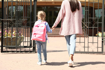 Wall Mural - Young mother taking her little child to school outdoors