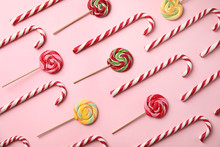 Flat Lay Composition With Candy Canes And Lollipops On Pink Background