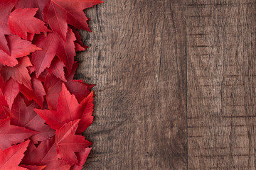 fall color nature background, red maple leaves on a rustic dark wood background