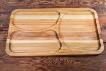 Empty wooden compartment dish with three departments on the rustic table