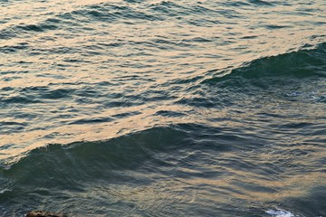 background texture of a calm deep ocean with ripples on the surface of the sea water ,warm tone colo