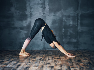 young attractive woman practicing yoga standing in downward facing dog asana ( adho mukha svanasana 